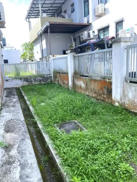 Exterior type: linked terrace house; features: overgrown grass, concrete pathway, drainage channel, fenced perimeter, visible air conditioning units, adjacent building structure, manicured lawn area, exposed concrete walls; style: modern.