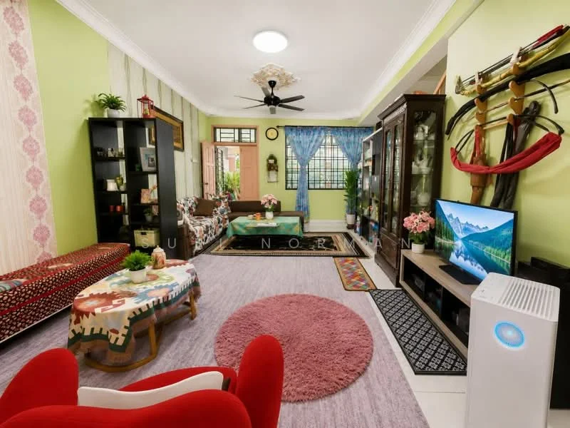 Living features: green painted walls, white ceiling with recessed lighting, 5-blade ceiling fan, wooden flooring, large window with sheer curtains, red fabric armchair, sofa with patterned upholstery, coffee table with colorful tablecloth, area rug with circular shape, black TV console, wall-mounted TV, decorative shelving unit, potted plants, decorative wall art, glass display cabinet; style: modern.