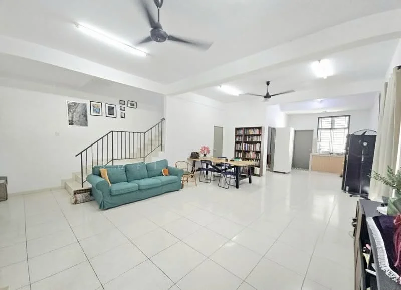 Living features: white painted walls, ceramic tile flooring, 5-blade ceiling fan, recessed downlights, green fabric sofa, coffee table, bookshelves, staircase, dining table with chairs, kitchen area visible in background; style: modern.