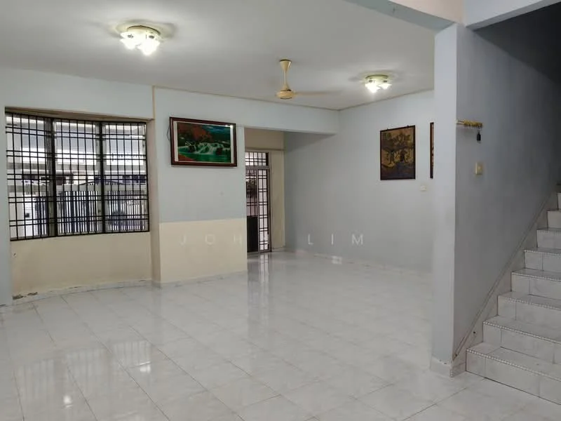Living features: white painted walls, glossy white tile flooring, 5-blade ceiling fan, two ceiling lights, large windows with metal grills, staircase leading to upper floor, decorative wall art, open layout.