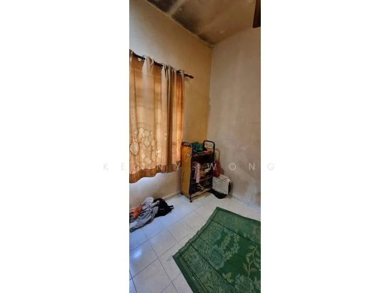 Room features: cream painted walls, white tiled flooring, brown wooden shelf, green area rug, curtains with floral pattern, small white cabinet, visible clutter on shelf.