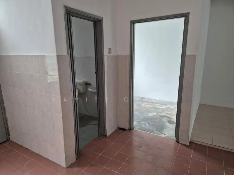 Room features: white painted walls, light grey tiled flooring, two doorways, one doorway leading to a bathroom, one doorway leading to an empty room, ceramic tile wall cladding, visible plumbing fixtures, no visible furniture or decor.