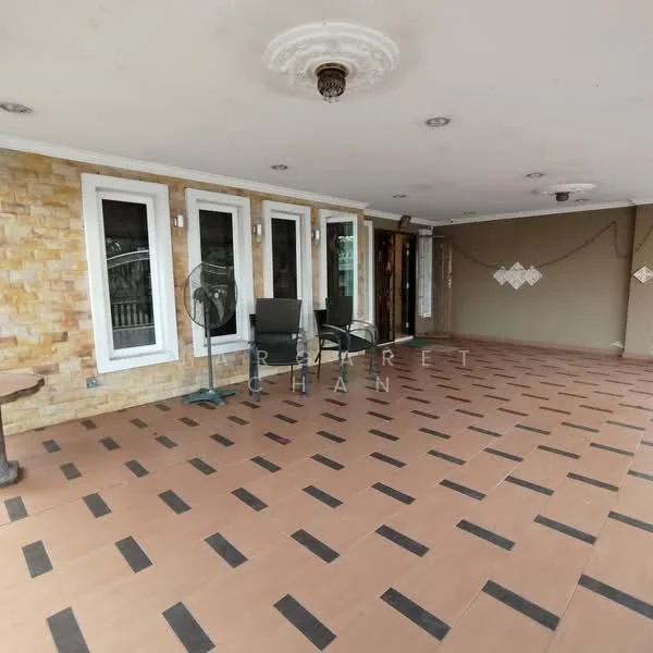 Room features: brick accent wall, cream painted walls, large windows, sliding glass door, tile flooring with black accents, ceiling rose, ceiling lights, outdoor seating area with chairs, fan, decorative wall elements; style: modern.