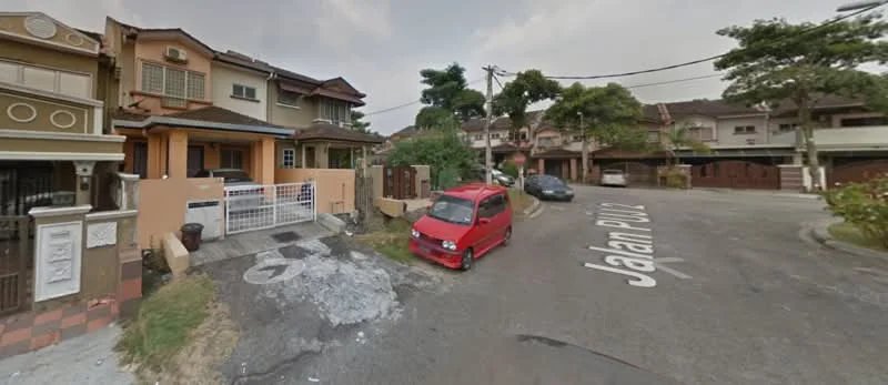 Exterior type: linked terrace house; features: two-storey building, cream painted facade, front porch with gate, manicured lawn, paved driveway, street view with road signage, surrounded by residential houses, visible parked car, mature trees in vicinity; style: modern.
