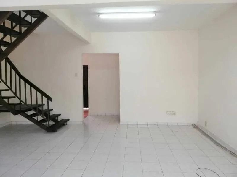 Living features: white painted walls, white tiled flooring, staircase with wooden railing, fluorescent ceiling light, open layout, doorway leading to another room, baseboard heating, no visible furniture.