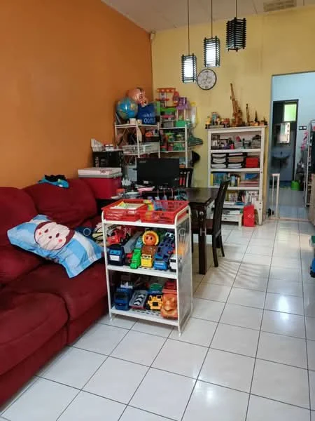 Living features: red fabric sofa, white tiled flooring, orange painted walls, black dining table with chairs, open shelving unit with toys, wall clock, decorative items on shelves, computer on desk, children's toys, blue throw pillow with snowman design.