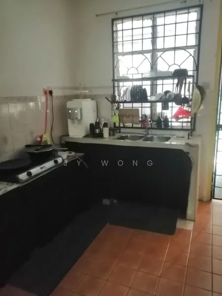 Kitchen features: double-bowl stainless-steel sink, chrome pull-down faucet, black countertop, wall-mounted kitchen shelves, various kitchen utensils, gas stove with 4 burners, white tiled backsplash, ceramic tile flooring, window with security bars, black curtains, two black mats on the floor.