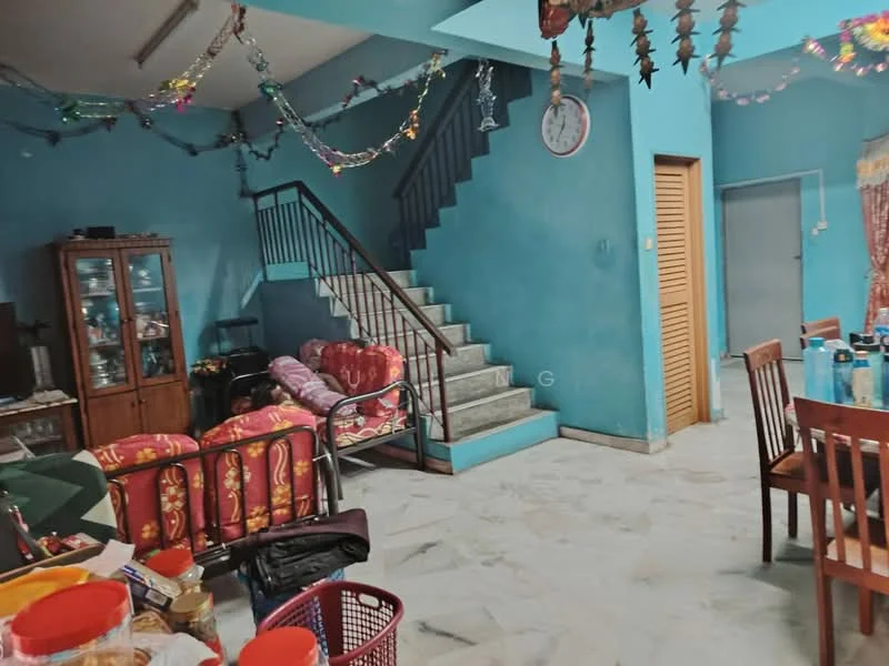 Living features: blue painted walls, marble flooring, staircase with metal railing, wall clock, decorative garlands, sofa with floral upholstery, wooden dining table, wooden cabinet, open layout, multiple light fixtures; style: traditional.