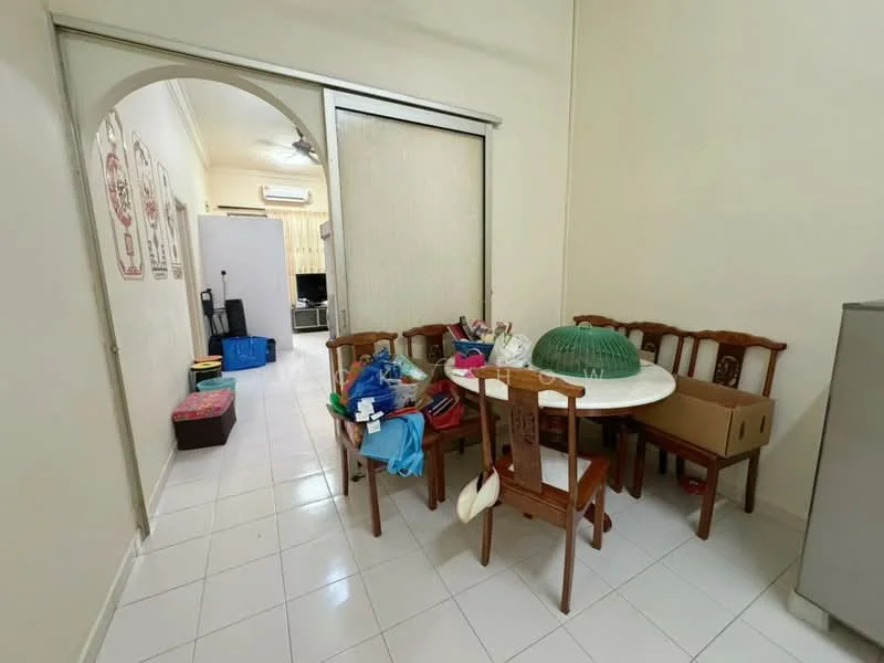 Dining features: round dining table, wooden dining chairs, white ceramic tableware, green food cover, tile flooring, cream painted walls, ceiling fan, wall-mounted TV visible in background, storage boxes, decorative items on table.
