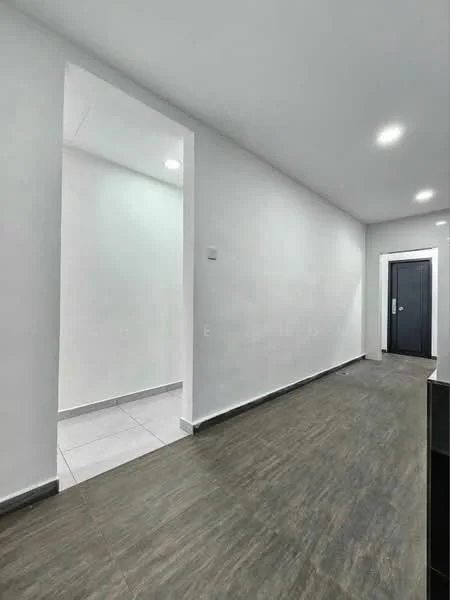Room features: white painted walls, grey laminate flooring, recessed downlights, door with black frame, tile flooring in adjacent area; style: modern.