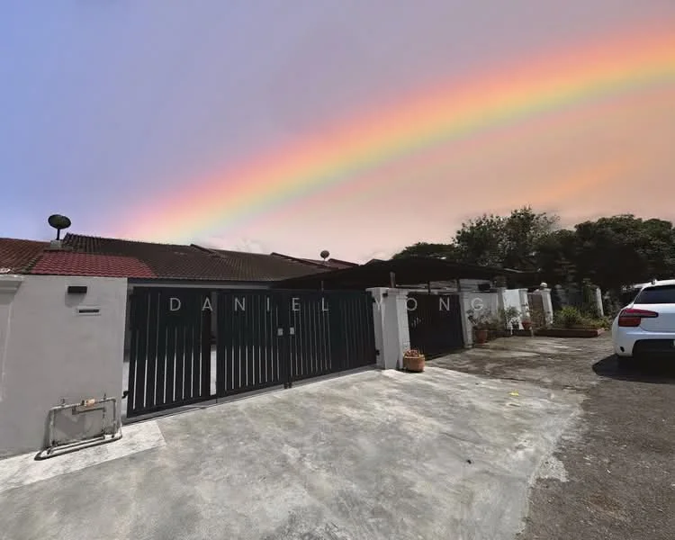 Exterior type: detached bungalow; features: grey painted facade, flat roof, manicured lawn, paved driveway, fenced perimeter, garden area with plants, visible car parked, rainbow in the sky; style: modern.