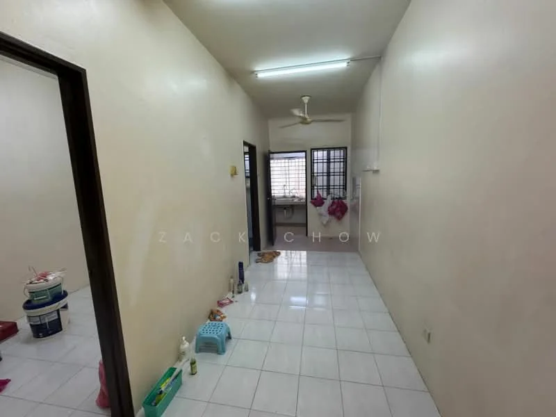Room features: white painted walls, glossy white tile flooring, ceiling fan, window with grille, doorway leading to another room, doorway leading to kitchen area, visible cleaning supplies, pet feeding area.