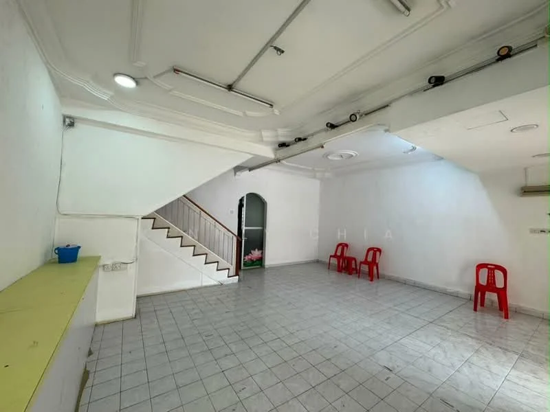 Room features: white painted walls, tile flooring, staircase with wooden railing, ceiling with recessed lighting, 2 ceiling fans, 3 red plastic chairs, green countertop, arched doorway, natural light from windows, no visible decor; style: minimalist.