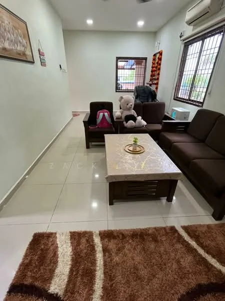 Living features: cream painted walls, white ceiling, marble tile flooring, 3-seater brown fabric sofa, 2-seater brown fabric sofa, coffee table with marble top, area rug with geometric pattern, large teddy bear, wall-mounted air conditioning unit, window with metal grille, decorative wall art; style: modern.