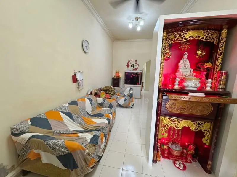 Living features: white painted walls, glossy tile flooring, ceiling fan, wall clock, sofa with patterned throw blanket, decorative altar with red and gold accents, small television, decorative items on altar, window with sheer curtains; style: traditional.