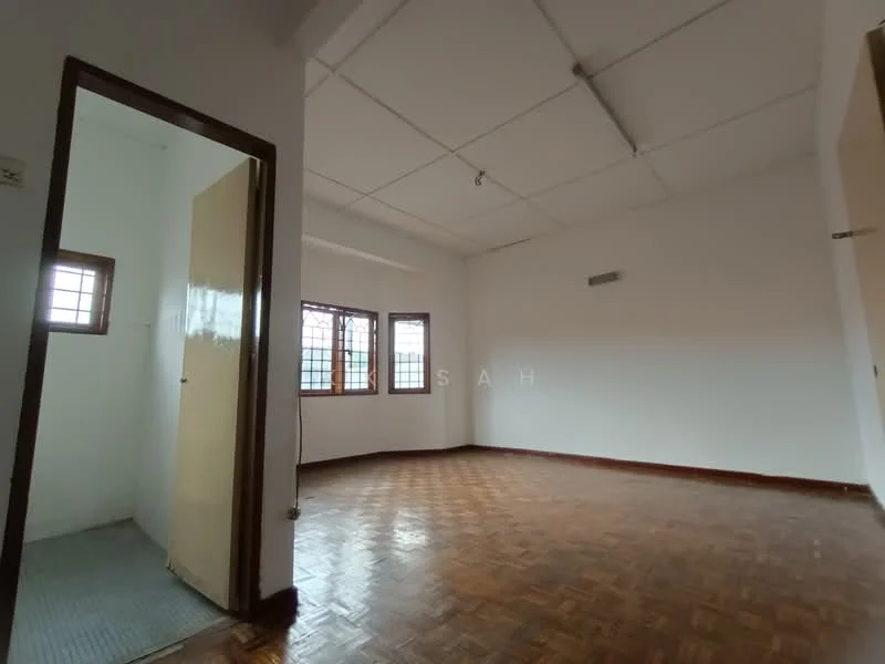 Room features: wood parquet flooring, white painted walls, ceiling with exposed beams, two windows with grid pattern, door leading to another room, light fixture on ceiling, empty space, no visible furniture.