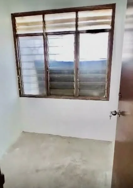Room features: white painted walls, concrete flooring, wooden window frames, sliding windows, single door, natural light from windows.