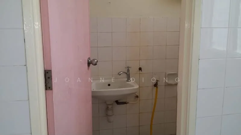 Bathroom features: white tiled walls, white tiled flooring, pink door, sink with chrome faucet, exposed plumbing, yellow hose, wall-mounted mirror, toilet paper holder.