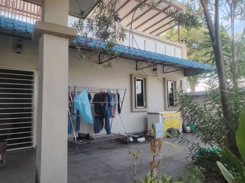 Exterior type: detached bungalow; features: blue tiled roof, white painted facade, laundry rack with clothes, outdoor washing machine, concrete flooring, landscaped garden with plants, windows with white frames, overhang for shade; style: modern.