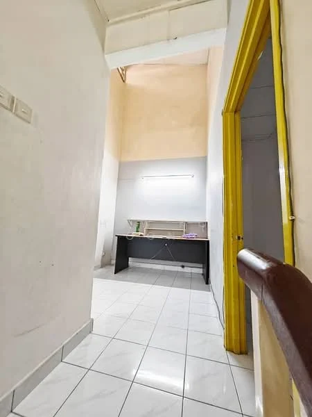 Room features: white painted walls, tiled flooring, high ceiling, fluorescent lighting, wooden railing, yellow door frame, desk or table against wall; style: minimalist.