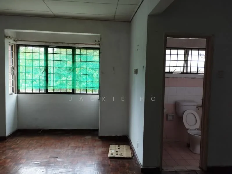 Room features: wooden flooring, white painted walls, two large windows with green view, visible bathroom with toilet, tile flooring in bathroom, window with metal grille, plain ceiling, doorway leading to bathroom; view: garden.