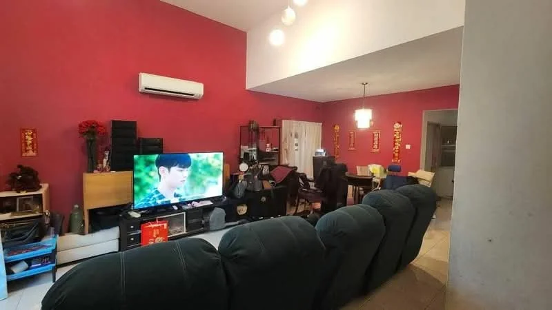 Living features: red painted walls, tile flooring, 5-blade ceiling fan with light, wall-mounted air conditioning unit, sofa in dark green fabric, large flat-screen TV, TV console in black, decorative wall art, dining table with chairs visible in background, shelving unit with various items, light fixture hanging from ceiling; style: modern.