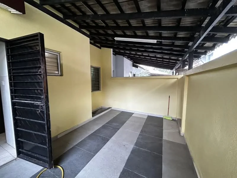 Room features: yellow painted walls, slate tile flooring, exposed beam ceiling, sliding black metal door, window with security bars, open space layout, covered area with roof, clean and tidy appearance.