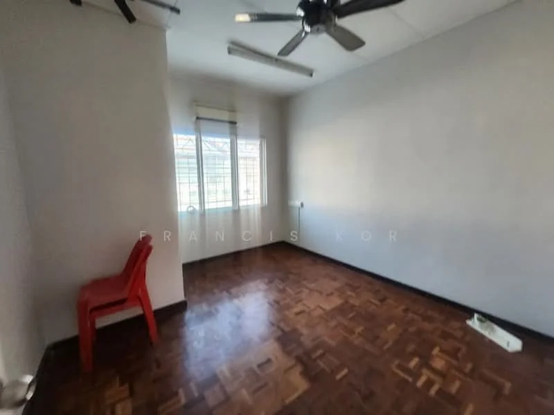 Room features: wooden flooring, grey painted walls, ceiling fan, window with grid, single plastic chair, baseboard, light source from window.
