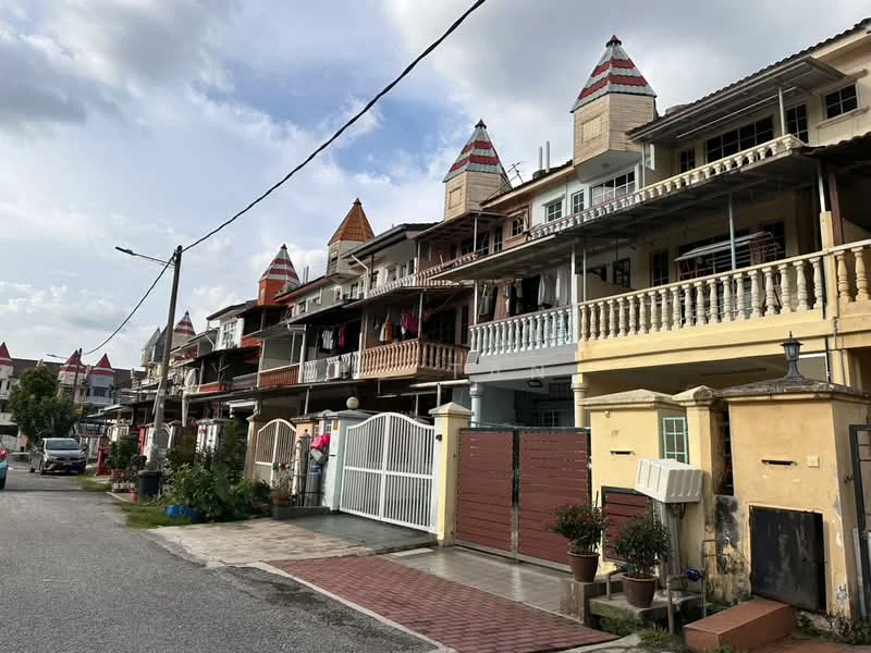 Exterior type: linked terrace house; features: two-storey linked terrace houses, red and cream painted facade, decorative gable roofs with red tiles, balconies with decorative railings, front gates with white fencing, paved walkway, landscaped front gardens with potted plants, visible air conditioning units, street lighting, surrounded by residential street; style: traditional.