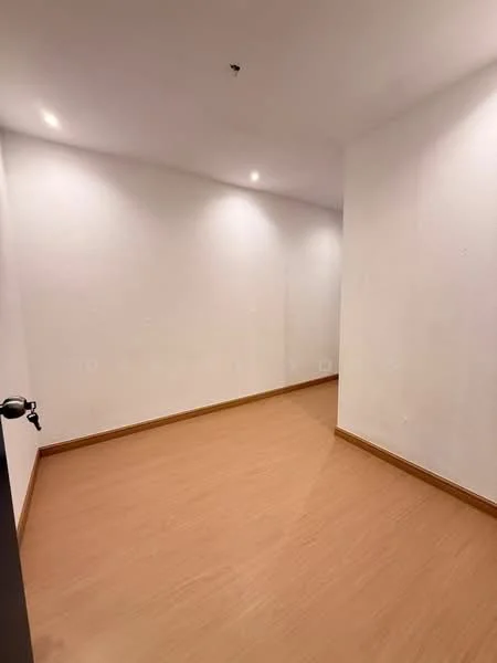 Room features: white painted walls, laminate flooring, recessed downlights, single door, corner room.