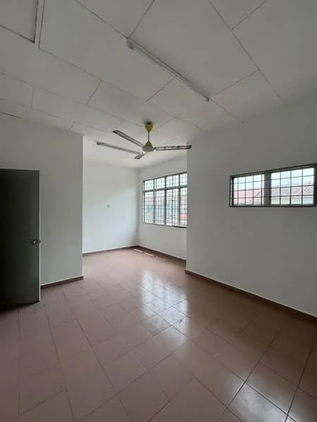 Room features: white painted walls, tile flooring in light beige, ceiling with fluorescent lights, ceiling fan, two windows with metal grilles, door to adjacent room.