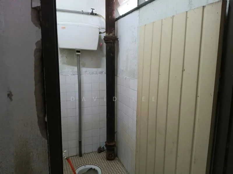 Bathroom features: white tiled walls, grey tiled flooring, water heater mounted on wall, exposed plumbing pipe, toilet bowl, partition wall, ventilation window.