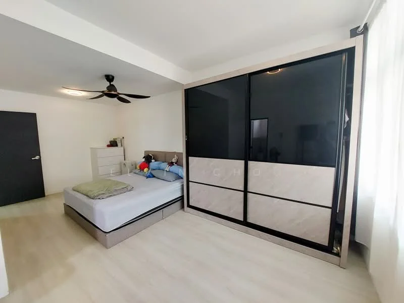 Bedroom features: queen-size bed, upholstered headboard, built-in wardrobe with sliding doors, white walls, light wood flooring, ceiling fan, natural light from window, decorative pillows, stuffed toys on bed, nightstand, LED ceiling light; style: modern.