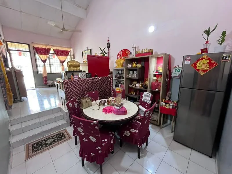 Dining features: round dining table with floral tablecloth, 4 upholstered dining chairs in red, white tiled flooring, cream painted walls, ceiling fan, decorative wall shelves, fridge, display cabinet with glass doors, red accent wall, decorative items on shelves, window with sheer curtains, area rug with floral pattern; style: traditional. Kitchen features: red cabinetry, stainless-steel fridge, countertop with decorative items, open shelving, kitchen appliances visible; style: traditional.