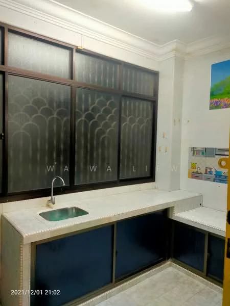 Kitchen features: single-bowl stainless-steel sink, chrome faucet, white countertop, blue cabinetry, tile backsplash, window with frosted glass, light-colored flooring, wall-mounted light fixture.