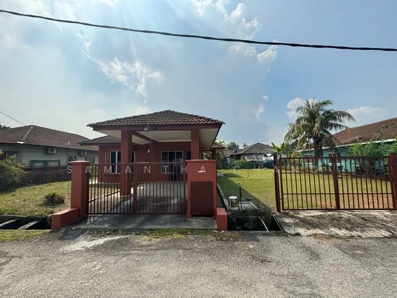 Exterior type: detached bungalow; features: red painted facade, pitched tile roof, single-storey, manicured lawn, paved driveway, fenced perimeter, covered porch, surrounded by greenery; style: modern.