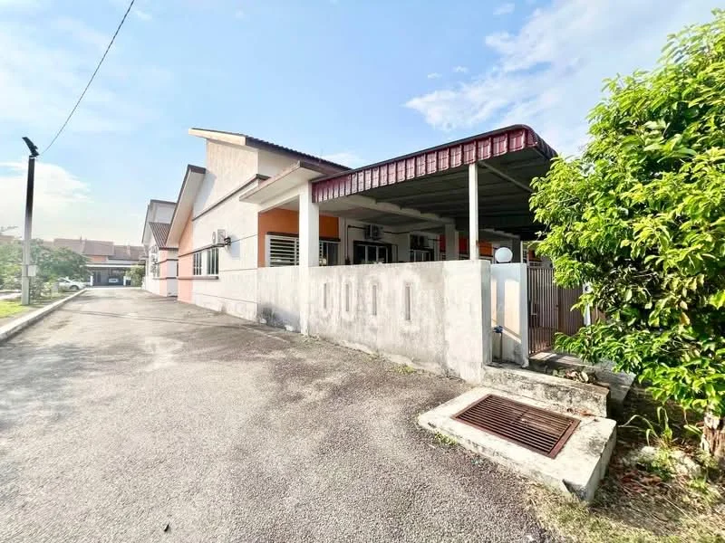 Exterior type: semi-detached house; features: single-storey, concrete facade, painted exterior, gabled roof, driveway with gravel surface, manicured landscaping, visible drainage grate, covered porch area, windows with grilles, side entrance gate; style: modern.