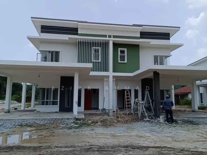 Exterior type: semi-detached house; features: two-storey building, white painted facade, green accent wall, large windows, projecting balconies, flat roof, manicured lawn in front, unfinished exterior with construction materials visible, scaffolding and ladders present, concrete driveway, surrounded by greenery; style: modern.
