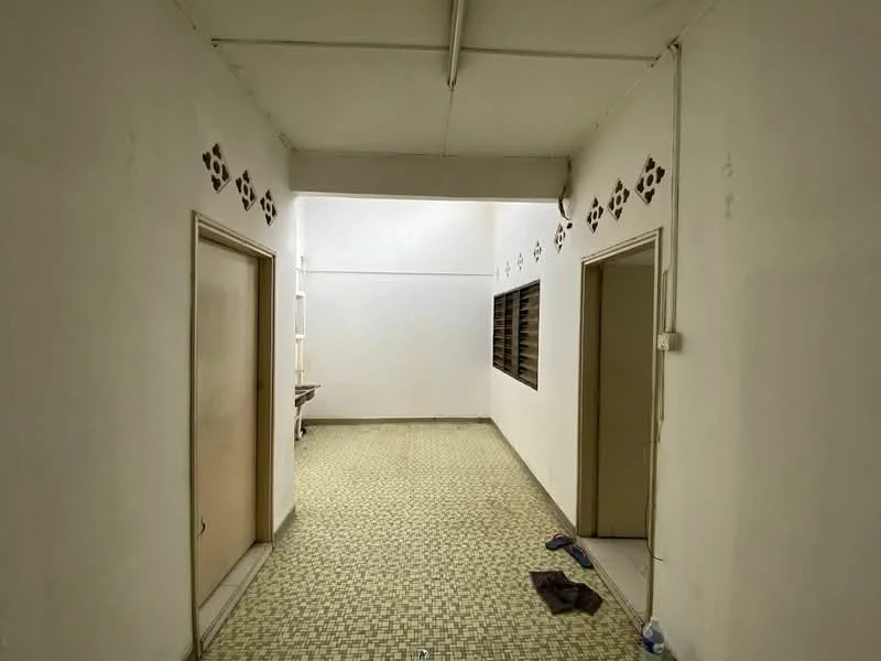 Room features: white painted walls, green patterned tile flooring, two wooden doors, window with horizontal bars, ceiling lights, exposed ceiling, wall-mounted shelving, baseboard, clean and uncluttered space; style: minimalist.