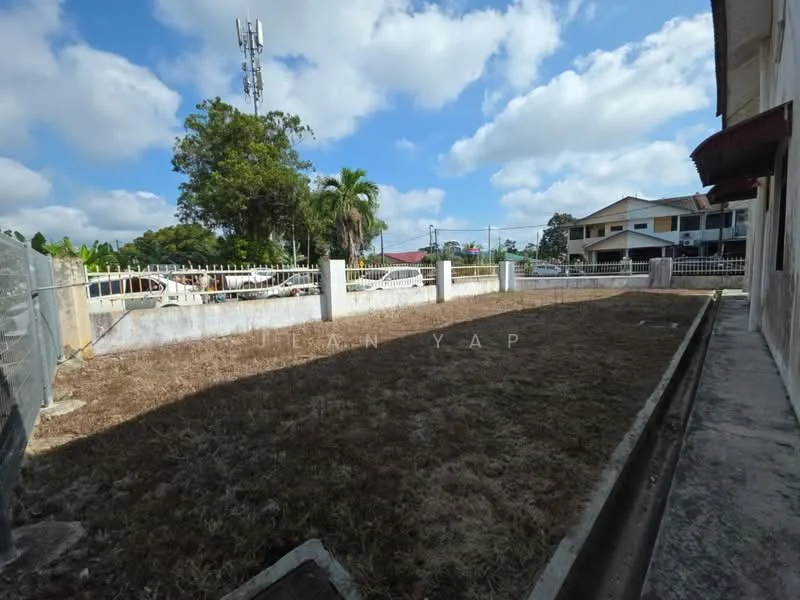 Exterior features: fenced perimeter, dry grass lawn, concrete pathway, surrounding trees, telephone tower in background, residential buildings in background, clear blue sky, clouds.