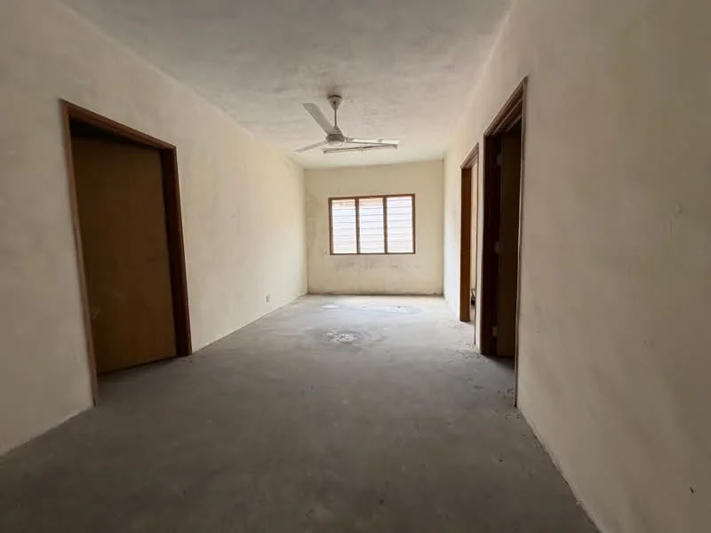 Room features: plain white walls, concrete flooring, ceiling fan, single window with horizontal slats, two doorways leading to other rooms.