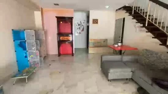 Living features: marble flooring, cream painted walls, staircase with wooden railing, grey fabric sofa, red dining table, decorative wall clock, open shelving unit, wall-mounted artwork; style: modern.