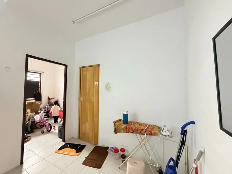 Room features: white painted walls, tile flooring, single wooden door, window with black blinds, small table with tablecloth, cleaning supplies, pet bowls, area rug, mirror on wall.