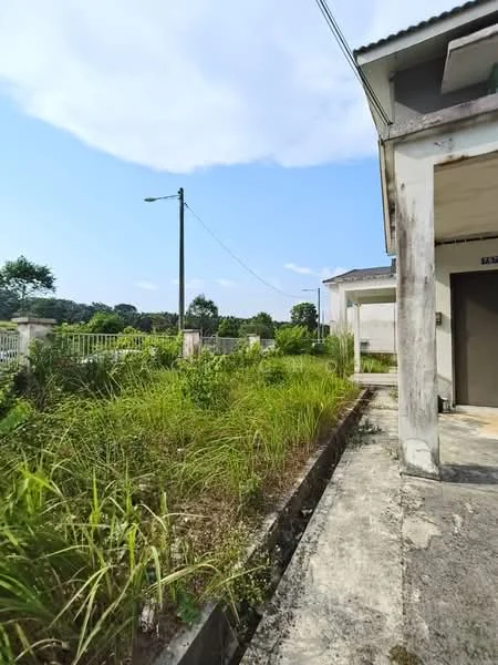 Exterior features: overgrown grass, concrete pathway, power pole, fence, surrounding greenery, partially visible building structure, clear blue sky, clouds.