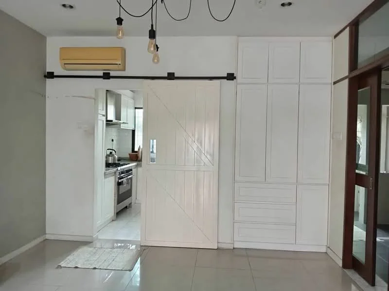 Room features: white painted walls, sliding barn door, built-in cabinetry with drawers, wall-mounted air conditioning unit, recessed lighting, tile flooring, open layout, natural light from windows; style: modern.