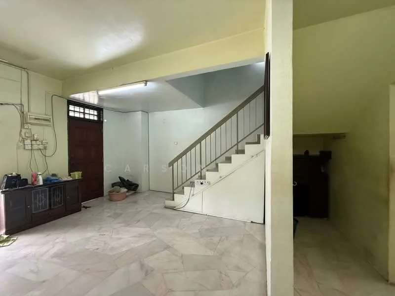 Room features: marble flooring, white painted walls, staircase with railing, wooden front door, wall-mounted electrical outlets, ceiling light fixture, corner with built-in cabinetry, open space layout.
