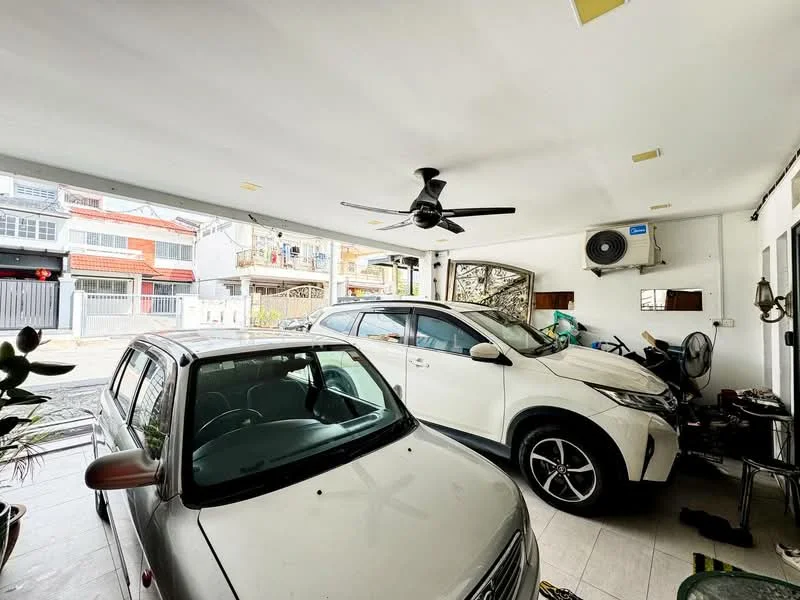 Exterior type: car porch; features: two vehicles parked, ceiling fan, wall-mounted split AC, white painted walls, tiled flooring, open space, natural light from large opening, decorative plants; style: modern.