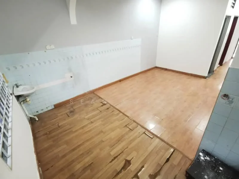 Room features: light wood laminate flooring, grey painted walls, blue tiled backsplash, exposed plumbing, flooring with visible damage, wall-mounted electrical outlets, doorway leading to hallway.