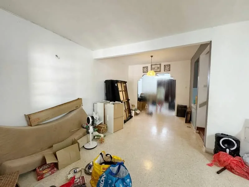 Room features: white painted walls, speckled tile flooring, ceiling light fixture, various boxes and bags on the floor, furniture including a sofa and storage units, partition wall with frosted glass, decorative wall art, open layout.