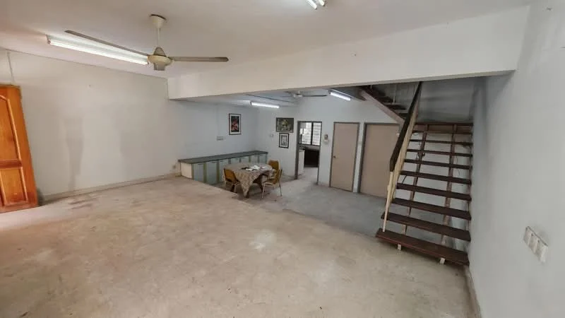 Room features: plain white walls, concrete flooring, ceiling with fluorescent lights, ceiling fan, wooden staircase, open layout, dining table with chairs, built-in cabinetry, multiple windows, doorway leading to another room; style: minimalist.